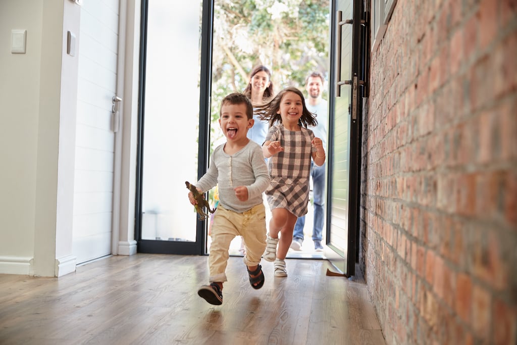Children running into the house with the parents walking in behind them.