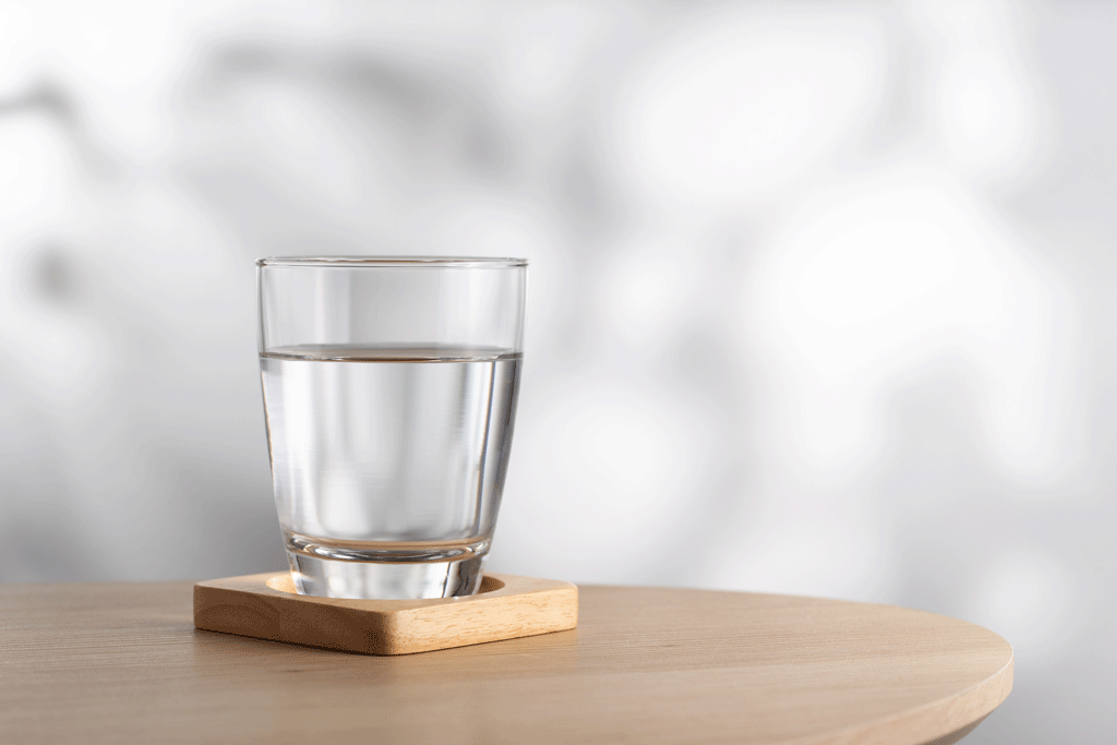 glass of water on wooden coaster water filtration system dallas tx frisco tx 