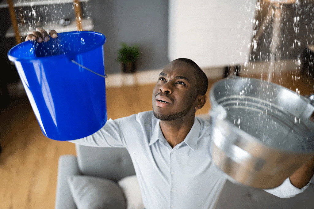 man holding buckets up to ceiling to catch water residential plumbing kingman az bullhead city az